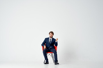 business man in suit sitting on red chair emotions office fun