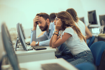 College students sitting in a classroom, using computers during class.
