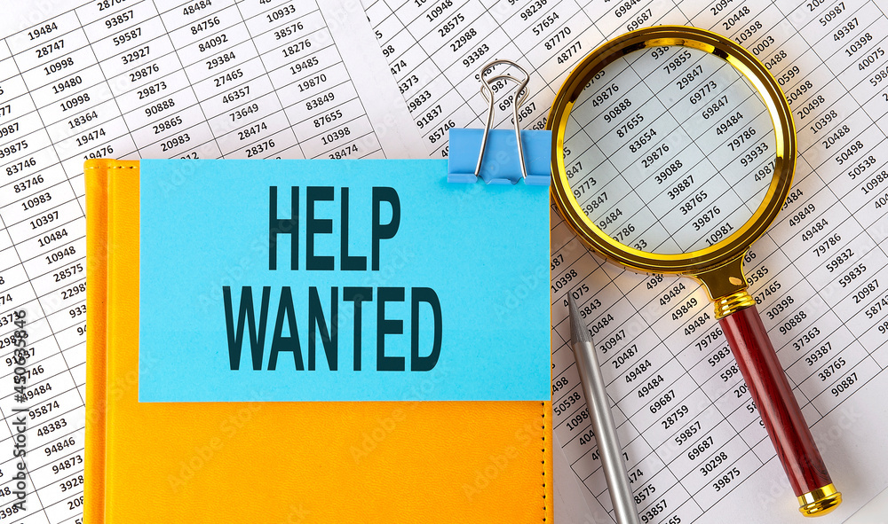 Aufkleber help wanted text on sticker on notebook with magnifier and chart. business concept