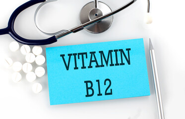 Text VITAMIN B12 on a table with a stethoscope,pills and pen, medical concept.