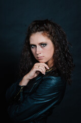 Portrait of sexy young woman posing in black jacket and jeans