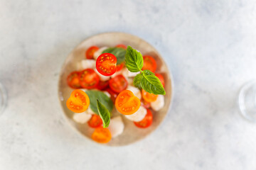 Delicious Italian Caprese salad with sliced red and orange cherry tomatoes.