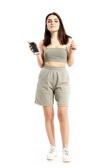 Fototapeta premium Young pretty gen Z woman listening to music on smart phone app dancing. Full body portrait isolated on white background