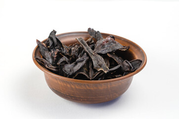 Dried dog treats in a brown clay bowl on a white background. Thi