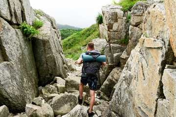 Back view hiker man with backpack going at hilly terrain natural mountain enjoy adventure