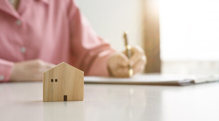 House model on sale keys on the rental agreement or the buy home contracts with the estate property background.