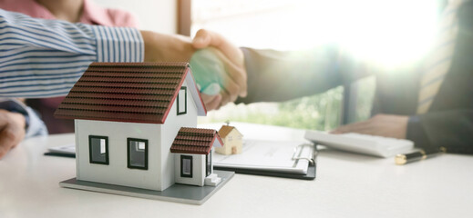 Real estate agent shaking hand with customer about house contract agreement..