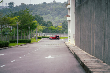 Road near the residential apartment area with an arrow. A car can be seen from distance.