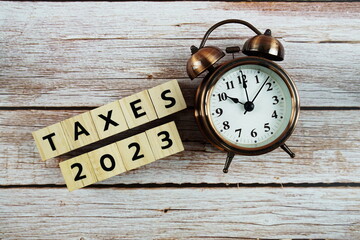 Taxes 2023 alphabet letter on wooden background
