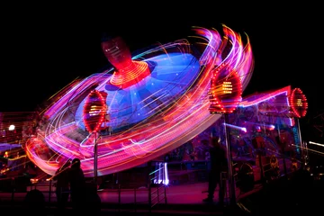 Schilderijen op glas Long exposure picture of a fairground ride at night © chris