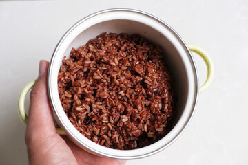Brown rice in a bowl. Top view isolated white