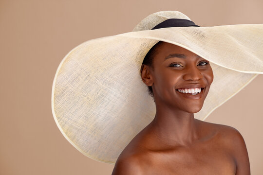Happy african woman wearing straw hat with a wide brim
