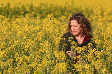 Naklejka na ściany i meble woman with yellow flowers field landscape background