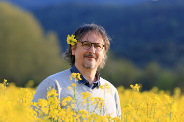 man in a yellow flowers field - Powered by Adobe