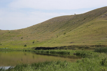 Fototapeta na wymiar beautiful green hill with a lake