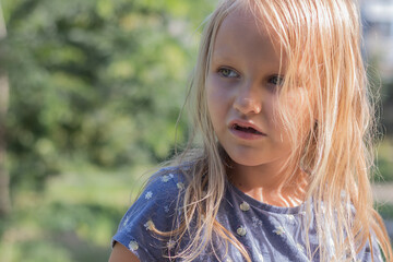 portrait of a child, a cute little girl 6-7 years old, a charming long-haired blonde, close-up, in nature