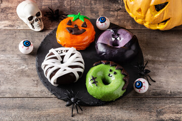 Assortmen of Halloween donuts on wooden table