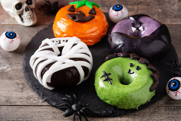Assortmen of Halloween donuts on wooden table