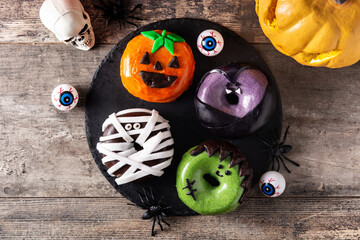 Assortmen of Halloween donuts on wooden table