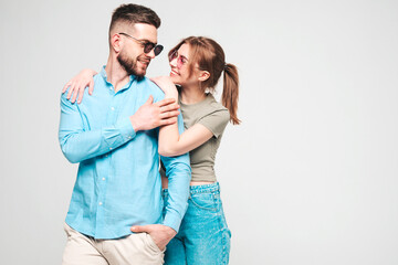Smiling beautiful woman and her handsome boyfriend. Happy cheerful family having tender moments on grey background in studio.Pure cheerful models hugging.Embracing each other in sunglasses