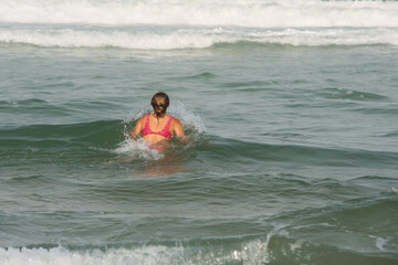 beautiful young woman having fun in the waves