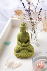 Candle Buddha on a white background, an element of home decor.