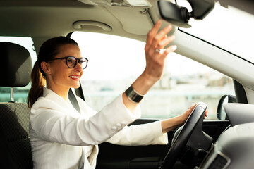 Beautiful businesswoman driving a car. Portrait of smiling woman sitting in the car..
