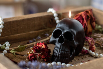 Black candle scull on witch table. Occult, esoteric, divination and wicca concept. Halloween, Day...