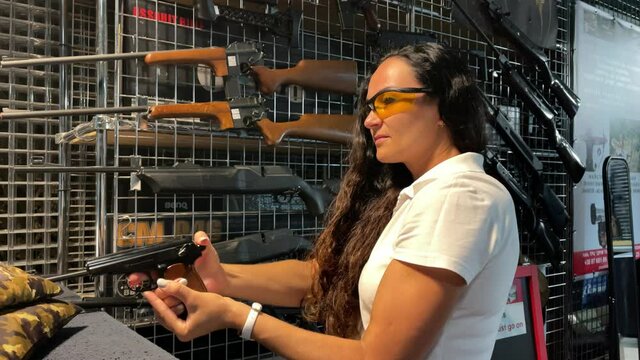 4k A woman learns how to shoot at the shooting range.