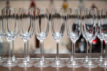 Champagne glasses on the table. Empty glasses are lined up ready to be served.