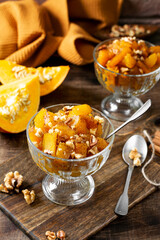 Traditional Turkish dish of baked pumpkin Kabak tatlisi in a glass bowl on a brown background. Delicious healthy dessert	