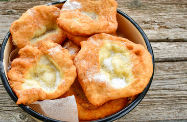 Traditional Bulgarian home made deep fried  patties  covered with sugar  оn rustic backgroud.Mekitsa or Mekica,  on wooden  rustic  background. Made of kneaded dough that is deep fried 