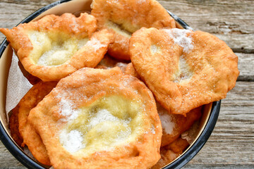 Traditional Bulgarian home made deep fried  patties  covered with sugar  оn rustic backgroud.Mekitsa or Mekica,  on wooden  rustic  background. Made of kneaded dough that is deep fried 