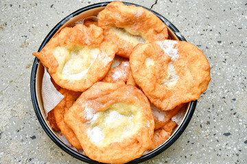 Traditional Bulgarian home made deep fried  patties  covered with sugar  оn rustic backgroud.Mekitsa or Mekica,  on wooden  rustic  background. Made of kneaded dough that is deep fried 