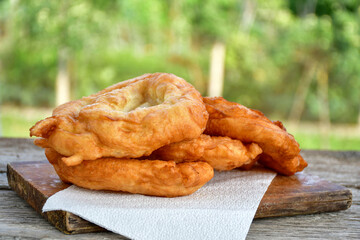Traditional Bulgarian home made deep fried  patties  covered with sugar  оn rustic backgroud.Mekitsa or Mekica,  on wooden  rustic  background. Made of kneaded dough that is deep fried 