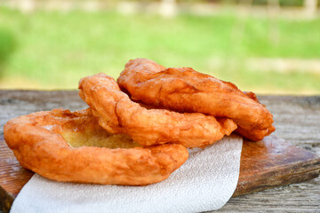 Traditional Bulgarian home made deep fried  patties  covered with sugar  оn rustic backgroud.Mekitsa or Mekica,  on wooden  rustic  background. Made of kneaded dough that is deep fried 