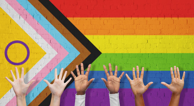lgbtq, trans and intersex rights concept - multiracial human hands over rainbow progress pride flag on background