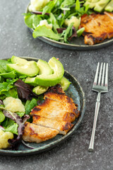 Dinner on the table, a plate of fried pork steak and a mix salad with cauliflower and avocado