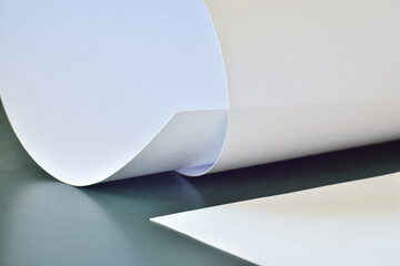 Sheets of white paper on a dark green table.