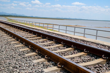 Fototapeta premium Focus on Railway Tracks in the bridge with background of water