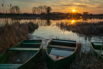 Boats on the shore of the lake and sunset