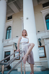 Obraz premium a beautiful girl in a skirt and top walks near the theater
