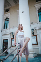 a beautiful girl in a skirt and top walks near the theater