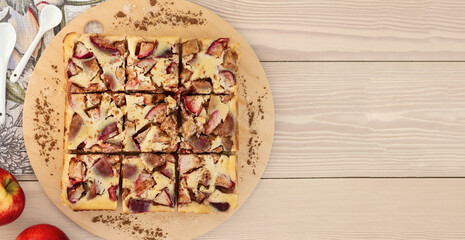 top view of quadrate apple pie with creamy filling cutting into pieces, autumn menu flatlay banner...