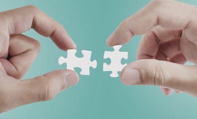 Hands connecting jigsaw puzzle