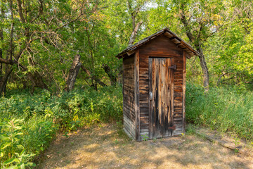 Fototapeta na wymiar Old Outhouse In The Woods