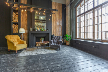dark brutal interior of sitting room decorated with wooden logs. yellow and grey soft armchairs,...