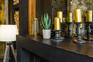 dark brutal interior of sitting room decorated with wooden logs. yellow and grey soft armchairs, huge arc window and fireplace