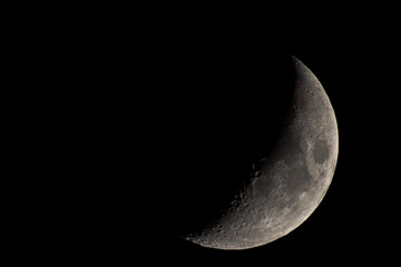 Obraz na płótnie Canvas Half a moon in the black night sky. Craters and lunar seas