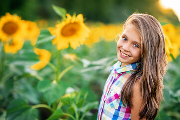 Portrait of a cute little girl in a field of sunflowers